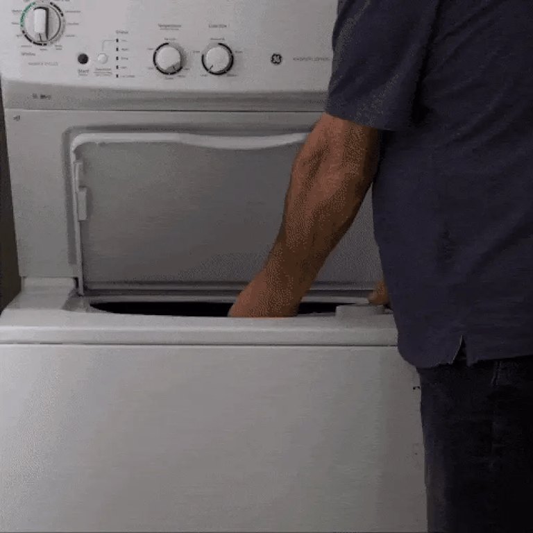 Person opening the lid of a top-loading washing machine